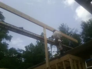 Carpenter setting a ridge beam over a new addition frame — Ice Dam Removal by Roofing Brothers in Grangeville