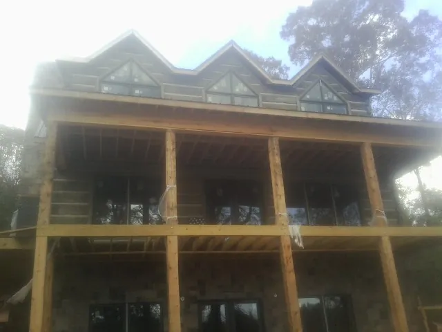 Dormers and porch framing on a large log home under construction — Roof Coating work by our crew in Grangeville