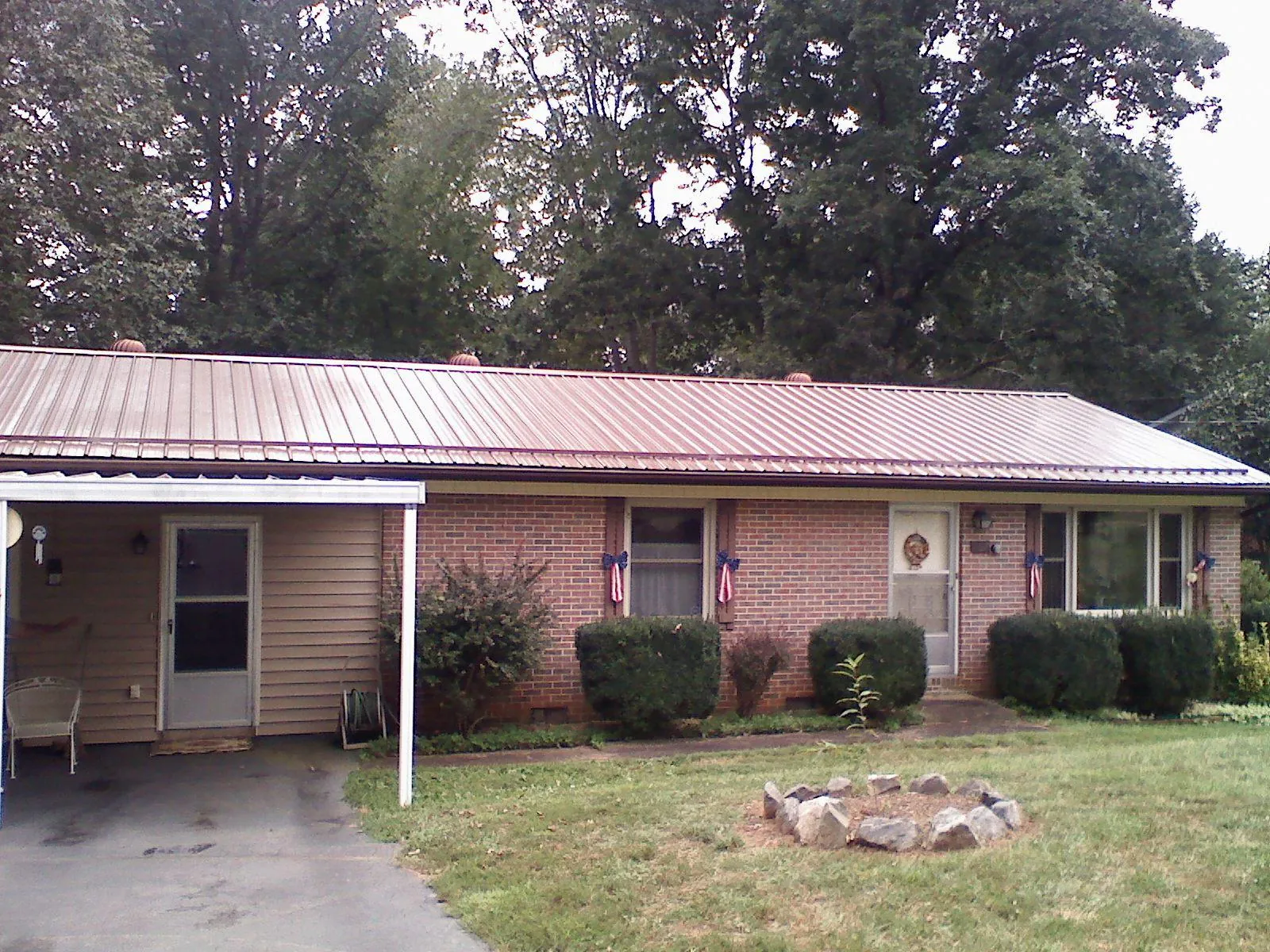 Bronze metal roof and carport on a brick ranch home — Roof Repair work by our crew in Grangeville