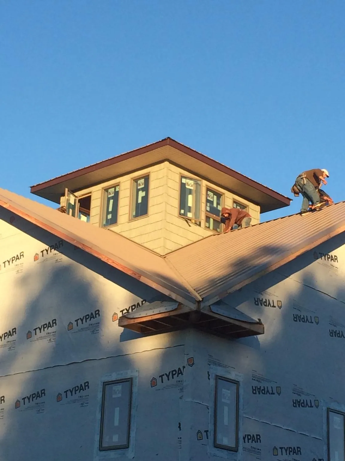 Roofers working around a rooftop cupola on a new metal roof at sunset — Roof Waterproofing in Grangeville by Roofing Brothers